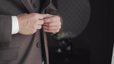 Damat, düğünden önce ceketini düzeltirken, damadın elleri ceketinin düğmesini düzeltirken ki görüntüsü..