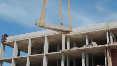 İnşaat alanında beton kaplama kaldırıldı. İnşaat alanındaki bir vinç tarafından büyük bir beton levha dikkatlice kaldırılıyor.