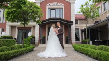 Düğün günü. Gelin ve damat zarif bir düğün yerinin önünde duruyor..