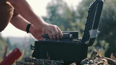 Erkek eller dronu katlar ve özel bir koruyucu çantaya koyar. El kameraları, küçük bir dronu depolamak için bavula katlıyor.