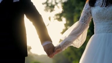 Altın saat boyunca gelin ve damat el ele tutuşuyor. Altın saat boyunca bir gelin ve damadın el ele tutuşması.