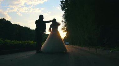 Sunset Açık Hava 'da Gelin ve Damat Dansı. Bir gelin ve damat gün batımında, gökyüzüne karşı dans ederken yakalandı.