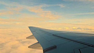 Altın saat boyunca bulutların üzerinde kanat çırpan uçaklar, bulutları kesen bir uçağın huzur dolu görüntüsü, altın çağında yakalanan