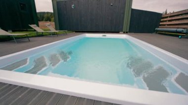 Tahta güvertede Dinlendirici Salon Sandalyeli Temiz Modern Havuz.