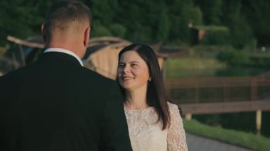Gelin Green Park 'ta damada gülümsüyor. Sıcak güneş ışığı romantik anlarının üzerine hafifçe parlıyor.