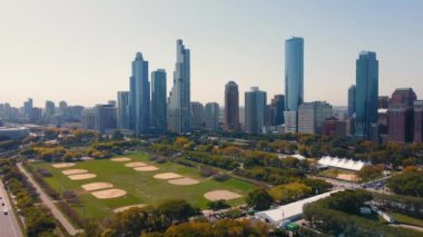 Grant Park ve Chicago ufuk çizgisinin hava görüntüsü. Şikago ufuk çizgisini gösteren hava manzarası ve açık bir günde Grant Parks spor sahaları ve yeşillik kentsel gökdelenlerle çevrili..