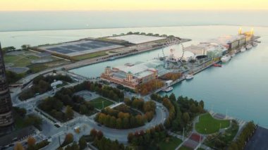 Chicago Donanma İskelesi ve Sunset 'te Skyline. Dönme dolabı, binaları ve Michigan Gölü ile Chicago Donanma İskelesi 'nin hava görüntüsü şehrin ufuk çizgisini aydınlatan günbatımına karşı.