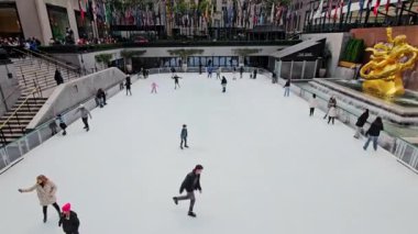 New York Eyaleti, Amerika Birleşik Devletleri, 10 Aralık 2024 Rockefeller Buz Pisti, Rockefeller Merkezi 'nde ziyaretçiler ve yerliler, yemyeşil ve uluslararası bayraklar gibi buz pistinde süzülüyorlar.