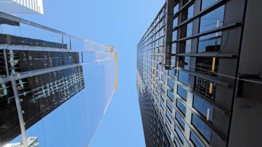 Chicago gökdelenlerinin dramatik manzarası, parlak mavi gökyüzünün altındaki modern mimari, güneş ışığını yansıtıyor..