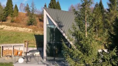 Güverte ve jakuzili Modern A-Frame Kabini. Modern bir A-frame kabin yakın plan cam ön cephe, açık hava güvertesi.