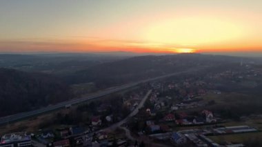 Taşra manzaralı, hareketli araçları, yuvarlanan tepeleri ve sıcak bir gökyüzünün altında küçük bir köyü olan Sunset Otoyolu 'nun Hava Manzarası