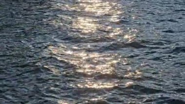 Yumuşak okyanus dalgalarına yansıyan güneş ışığı, okyanusun yüzeyinden yansıyan altın güneş ışığı..