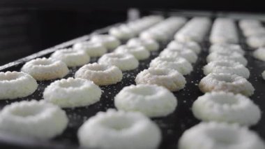 Pişirme tepsisine şeker serpiştirilmiş taze şekilli kurabiyeler, tepsiye şeker serpiştirilmiş sıra sıra çiğ kurabiyeler.