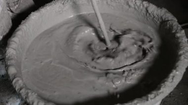 İnşaat için sıvı çimentoyu karıştırmak, büyük bir konteynıra karıştırılan sıvı çimentoyu yakın çekim yapmak..