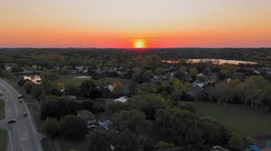 Renkli bir gökyüzü olan banliyö gün batımı manzarası, günbatımında canlı renklerle ve sakin bir atmosferle banliyö manzarası. Wisconsin, Amerika Birleşik Devletleri.