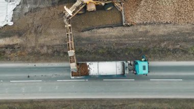 Hasat makinesinden bir kamyona şeker pancarı yüklemek, hasat makinesinden şeker pancarı yüklü bir kamyonun üst görünümü