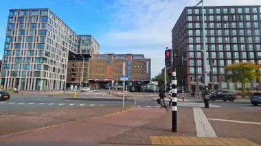 Amsterdam Hollanda 28.10.2024 Modern şehir caddesi Amsterdam 'da yüksek ofis binaları, trafik ışıkları ve yaya geçitleriyle.