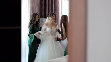 Nedimelerle mutlu gelin, zarif bir iç mekanda düğün hazırlığı yapıyor..