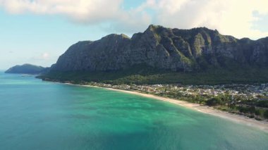 Turkuaz suları olan Waimanalo Sahili, sahil boyunca uzanan altın kumlar, Honolulu Watershed Ormanı 'nın yemyeşil uçurumları.