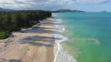 Waimanalo Sahili 'nin havadan görünüşü, turkuaz okyanus dalgaları yumuşak altın kumla buluşması, tropik kıyı şeridi boyunca uzanan yemyeşil kıyı şeridi..