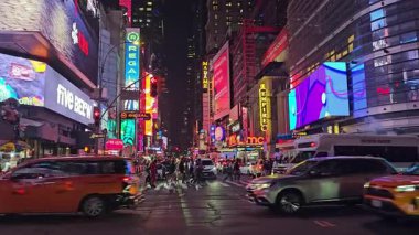 - New York. Biziz. 03.02.2025. Gece Times Meydanı 'nda parlak neon panolar, yoğun trafik ve kalabalık kavşaktan geçen yayalar.