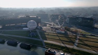 Krakow, Polonya 01.02.2025 Dönme dolap, lunapark ve şehir manzarası, modern ve tarihi mimariye sahip canlı kentsel manzara