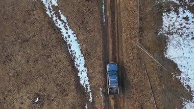 Çamurlu kırsal yoldaki kamyonetin hava görüntüsü çamurlu kırsal yolda giden bir kamyonetin tepeden aşağı insansız hava aracı görüntüsü..