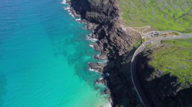 Hawaii 'deki dolambaçlı kıyı yolunun hava manzarası, sarmal bir yola bakan insansız hava aracı görüntüsü turkuaz su üzerindeki sarp kayalıkları Makapuu yakınlarındaki Hawaii kıyı şeridi boyunca kucaklıyor..