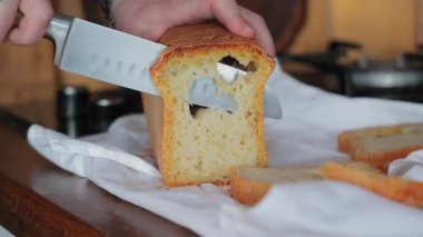 Havadar ev yapımı ekmek dilimleme yakın çekim ahşap masa üzerinde beyaz mutfak havlusu ile.