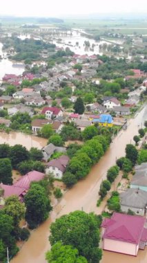 Su basmış evlerin ve şehrin yukarıdan görünüşü. Dağlardan akan seller... Evler sel basmış nehrin kirli suyuyla dolup taşıyor..