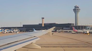 Chicago, ABD. 12 Ekim 2024, Chicago OHare havaalanı, kontrol kuleleri ve pistteki uçak kanadı görüntüsü..