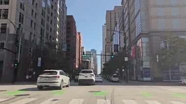 Chicago, ABD. 13 Ekim 2024, şehir merkezi boyunca şehir trafiği yüksek binalar ve görünür vitrin levhaları..