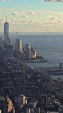 New York Şehri Skyline ve Hudson Nehri Manzarası, tekneler ve parçalı bulutlu gökyüzünün altındaki Özgürlük Heykeli.