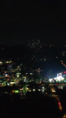 Şehir Nightscape 'i havai fişeklerle aydınlatılan havai fişeklerle aydınlanan şehir gece manzarası şehir ışıklarının üzerinde parlayan parlak kırmızı ve altın havai fişekler.