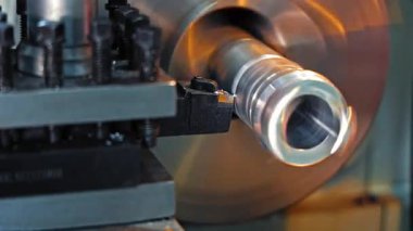Metal torna makinesinde döndürme işlemine yakın çekim, döngü silindirik kısmını kesme aracı hassasiyet mekanizmasında.
