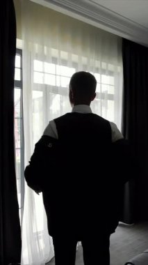 Gelin ve damat pencerenin kenarında güzel bir anı paylaşıyorlar, gelin ve damadı pencerenin kenarında yan yana gösteren güzel bir görüntü.