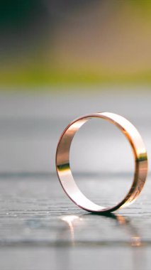 Ahşap bir yüzeyde yan yana duran iki alyans, evlilikteki birlikteliğin ve bağlılığın sembolünü vurgular.