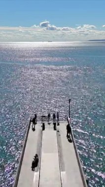 İskeleli parlak bir okyanusun havadan görünüşü, Coney Adası Sahili 'ndeki manzaranın tadını çıkaran insanlar..