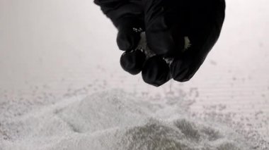 Eldivende beyaz plastik granüller, enjeksiyon kalıplarında veya ekstrüzyon imalatında kullanılan polimer hammaddeler tutan işçiler..