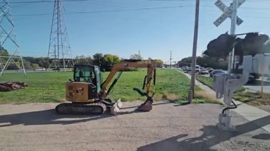 ABD, Libertyville, 2024-10-09, Demiryolu geçidi kırmızı ışıklarla, arabalarla ve kamyonla bariyerin arkasında bekliyor..