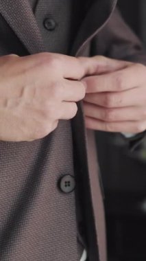 Damat, düğünden önce ceketini düzeltirken, damadın elleri ceketinin düğmesini düzeltirken ki görüntüsü..