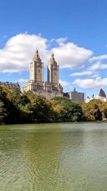 New York 'ta ikonik binaların, yemyeşil suların ve mavi gökyüzünün altında sakin suların olduğu hızlandırılmış Central Park tekne sahnesi.,