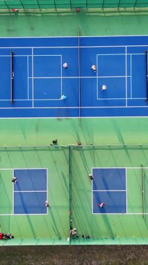 Sahada Aktif Pickleball Oyunu 'nun Drone Atışı' nda Hava Görünümü, oyuncuların aktif olarak yer aldığı açık hava Pickleball sahaları.