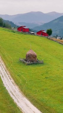 Dağların arka planında iki kırmızı evi olan gökyüzü manzaralı bir dağ manzarası. Dağlarda ahşaptan yapılmış ahşap ekolojik evler.