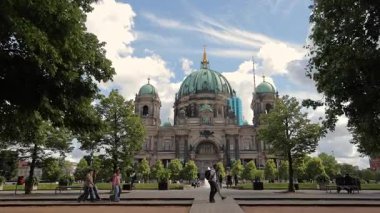 Berlin Almanya 25.05.2025, Berliner Dom Lush Green Trees ve Ziyaretçiler, Iconic Neo-Baroque Katedrali ile çevrili Parlak Yaz Gökyüzü Altında Bakır Domes.