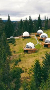 Beyaz, yuvarlak ormandaki modern fütüristik evler. Evin yanında birbirine aşık genç bir çift.