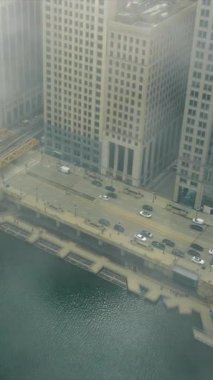 Chicago şehir merkezindeki hava manzarası, araba trafiği ve kuş bakışı şehir hayatı. Banliyö metro trenlerinin ve insanların yoğun saatlerde yaptıkları hareketler. Chicago Illinois ABD 'de bulutlu bir gün ve sis