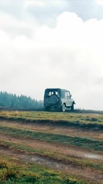 Araba bataklık bir çayırda sürükleniyor. Bir dağın tepesinde iki araba. Bataklıkta sürüklen