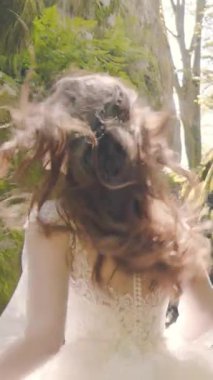 Dalgalı bir elbise içinde gülümseyen gelin kayaların arasından kameraya doğru koşuyor. Güneşin arka ışığı parlama ve sıcaklık yaratır, enerji ve mutluluğu yakalar..