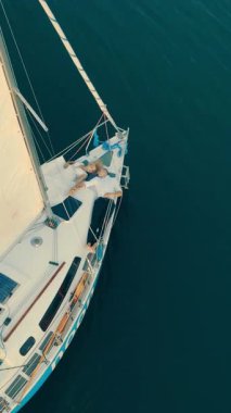 Ukrayna. Lviv. 19.09.2020. Yatın yukarısında, insansız hava aracı parlayan denizi filme alır. Sakin su günbatımı bulutlarını yansıtır, yelken ve gökyüzü altın tonlarda harmanlanır..